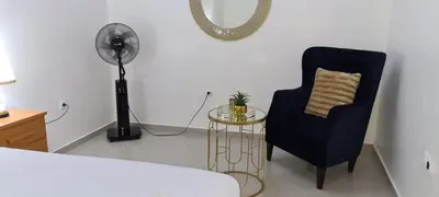 a room with a chair and a table and a fan at Zeyden Place Apt in Praia