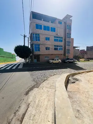 a large building with cars parked in front of it at Zeyden Place Apt in Praia