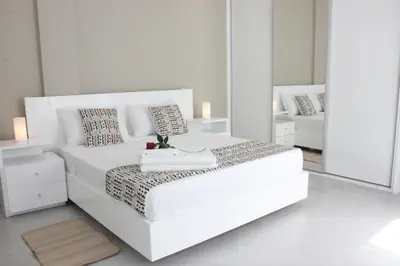 a white bedroom with a white bed and a mirror at KANDAKE APARTMENT Sal Rei Wi-Fi in Sal Rei
