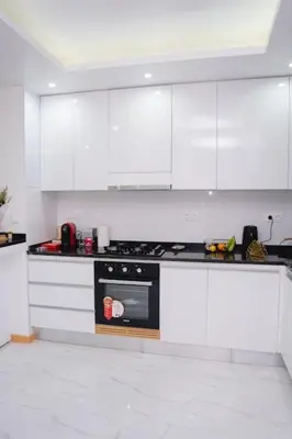a kitchen with white cabinets and a black stove at Saw Paradise in Praia T2 in Praia