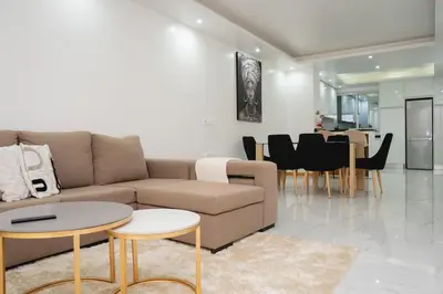 a living room with a couch and a table and chairs at Saw Paradise in Praia T2 in Praia