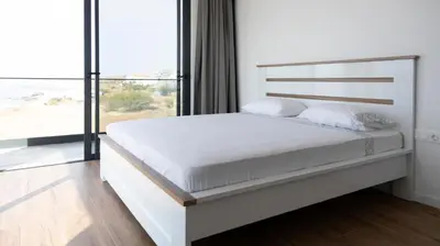 a white bedroom with a large bed and a large window at Lux 3-BR: Panoramic Sea View & Rooftop Pool in Praia