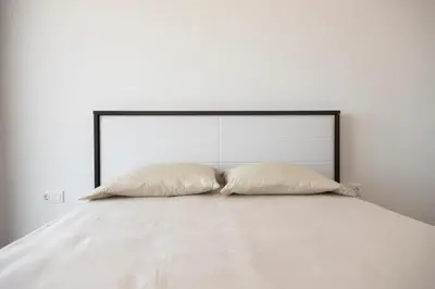 two pillows sitting on top of a white bed at Lux 3-BR: Panoramic Sea View & Rooftop Pool in Praia
