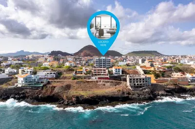a view of a city from the ocean with a blue marker at Lux 3-BR: Panoramic Sea View & Rooftop Pool in Praia