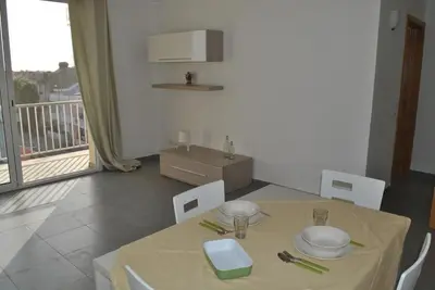 a dining room with a table and chairs and a balcony at Ideal Location in Sal Rei