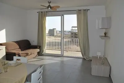 a living room with a couch and a sliding glass door at Ideal Location in Sal Rei