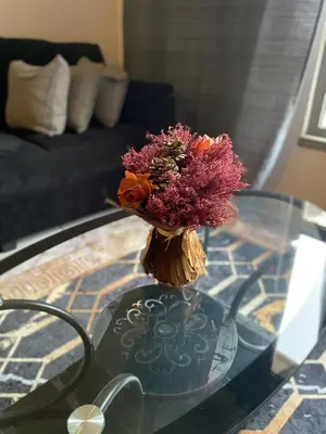 a vase of flowers sitting on a glass table at Apartamento T2 Equipado e Aconchegante. in Praia