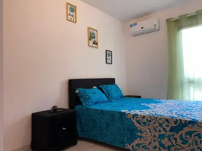 a bedroom with a bed with blue sheets and a window at Apartamento T2 Equipado e Aconchegante. in Praia