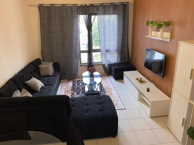 a living room with a blue couch and a tv at Apartamento T2 Equipado e Aconchegante. in Praia