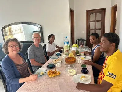 a group of people sitting at a table eating food at Casa dos Amigos in Calheta de São Miguel