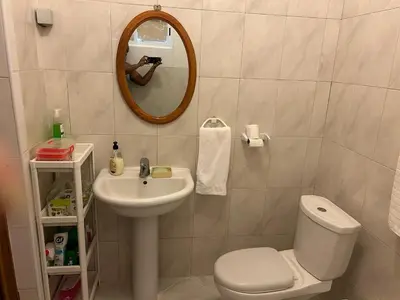 a bathroom with a sink and a toilet and a mirror at Casa dos Amigos in Calheta de São Miguel