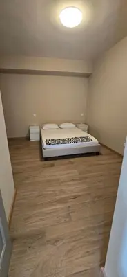 a bedroom with a bed and a wooden floor at Flat City Center Mindelo in Mindelo