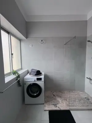 a washing machine in a bathroom with a window at MorabezaHome- Apartment Tati in Mindelo