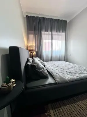 a bedroom with a bed and a chair and a window at MorabezaHome- Apartment Tati in Mindelo