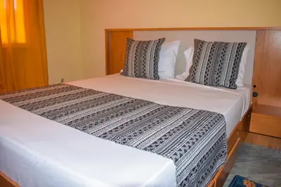 a bedroom with two beds with white sheets and pillows at De Pina Apartments in Pedra Badejo
