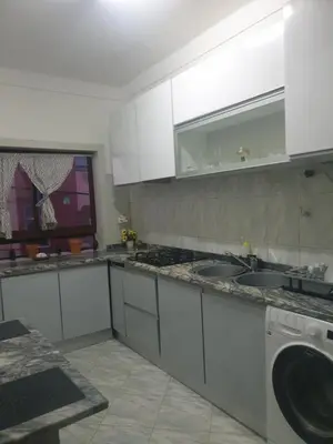 a kitchen with white cabinets and a sink and a dishwasher at De Pina Apartments in Pedra Badejo