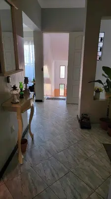 a living room with a table and a hallway at De Pina Apartments in Pedra Badejo
