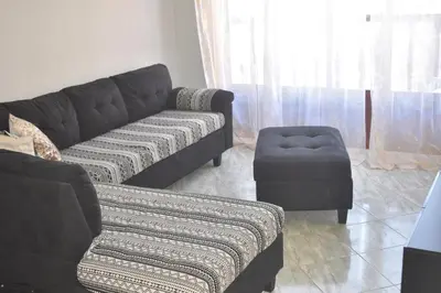 a living room with a couch and a stool at De Pina Apartments in Pedra Badejo