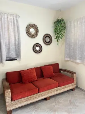 a red couch sitting in a living room with a window at Sal Breeze in Santa Maria