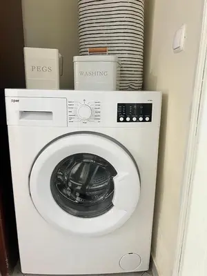 a white washing machine sitting in a room at Sal Breeze in Santa Maria