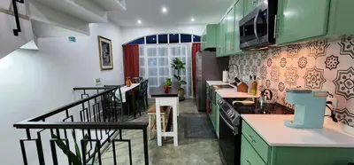 a kitchen with green cabinets and a counter top at Casinha Nova - Comfort & Class in Fogo in São Filipe