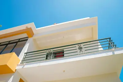 a white house with balconies and a blue sky at JT Sea View Apartment T3 in Praia