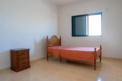 a bedroom with a bed and a dresser and a window at JT Sea View Apartment T3 in Praia