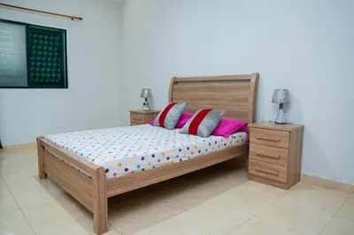 a bedroom with a wooden bed with pink pillows at JT Sea View Apartment T3 in Praia