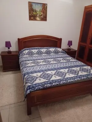 a bedroom with a bed with a blue and white quilt at Repousando II in Ribeira Grande