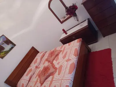 a bedroom with a bed and a mirror on the wall at Repousando II in Ribeira Grande