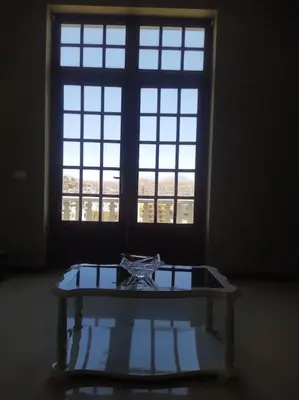 a glass table in front of a large window at Vivenda com pátio, no coração do Mindelo in Mindelo
