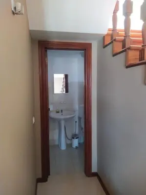a hallway with a bathroom with a sink and a mirror at Vivenda com pátio, no coração do Mindelo in Mindelo