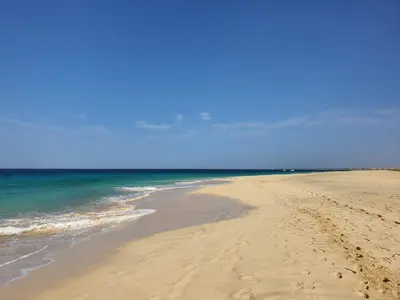 a sandy beach with the ocean and the sky at Casa Verde in Santa Maria