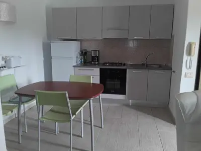 a kitchen with a table and chairs and a kitchen with white cabinets at Casa Verde in Santa Maria