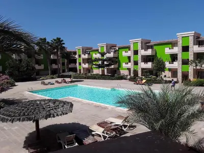 a swimming pool in front of a large apartment building at Casa Verde in Santa Maria