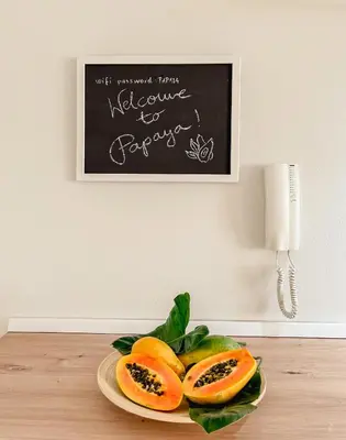 a plate of fruit on a table with a chalkboard at Papaya Apartments Boa Vista in Sal Rei