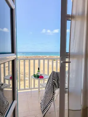 a balcony with a table and a view of the beach at Papaya Apartments Boa Vista in Sal Rei