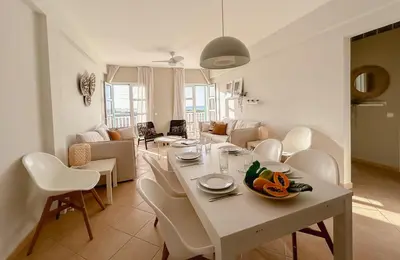 a dining room and living room with a table and chairs at Papaya Apartments Boa Vista in Sal Rei