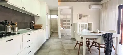 a kitchen with white cabinets and a table and chairs at Papaya Apartments Sal Island in Santa Maria