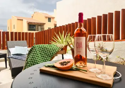 a bottle of wine and a glass on a table at Papaya Apartments Sal Island in Santa Maria