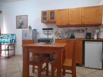 a kitchen with wooden cabinets and a wooden table at Apto Martins - Prédio Residencial Inês nº23 in Vila do Maio