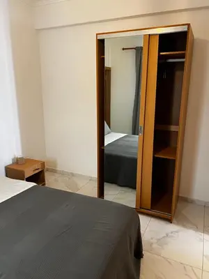 a bedroom with a bed and a mirror at Pensão Gonçalves in Calheta de São Miguel