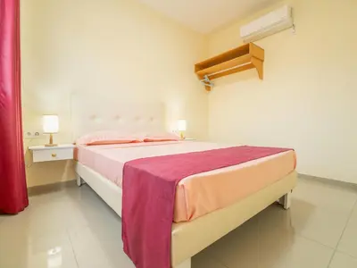 a bedroom with a large bed with pink sheets at Residencial LiviaMilena Santa Maria in Santa Maria