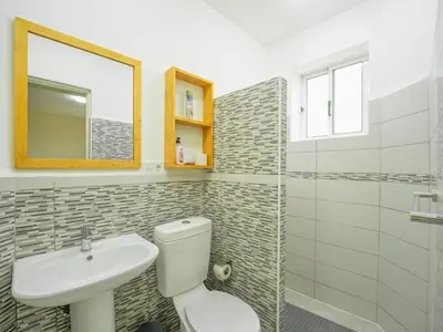 a bathroom with a toilet and a sink and a mirror at Residencial LiviaMilena Santa Maria in Santa Maria