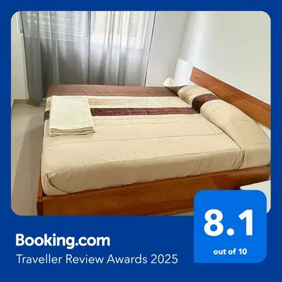 a bed in a small room with avertisement for at Apartamento Da Costa in Mão para Trás