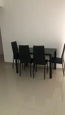 a black dining room table with four black chairs at Apartamento Da Costa in Mão para Trás