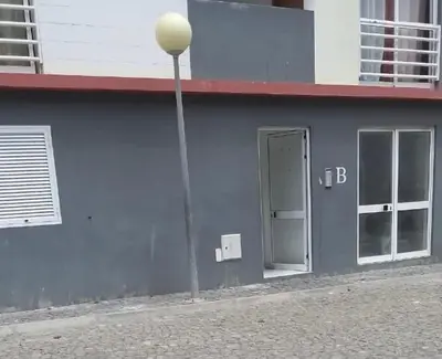 a blue building with a door and a street light at Apartamento Da Costa in Mão para Trás