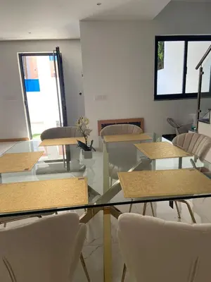 a dining room with tables and chairs and a window at Rosario’s Residence in Praia