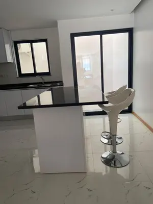 a glass table and a white chair in a room at Rosario’s Residence in Praia