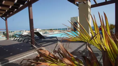 a patio with a swimming pool with a view of the ocean at Geams Sal Suite in Santa Maria